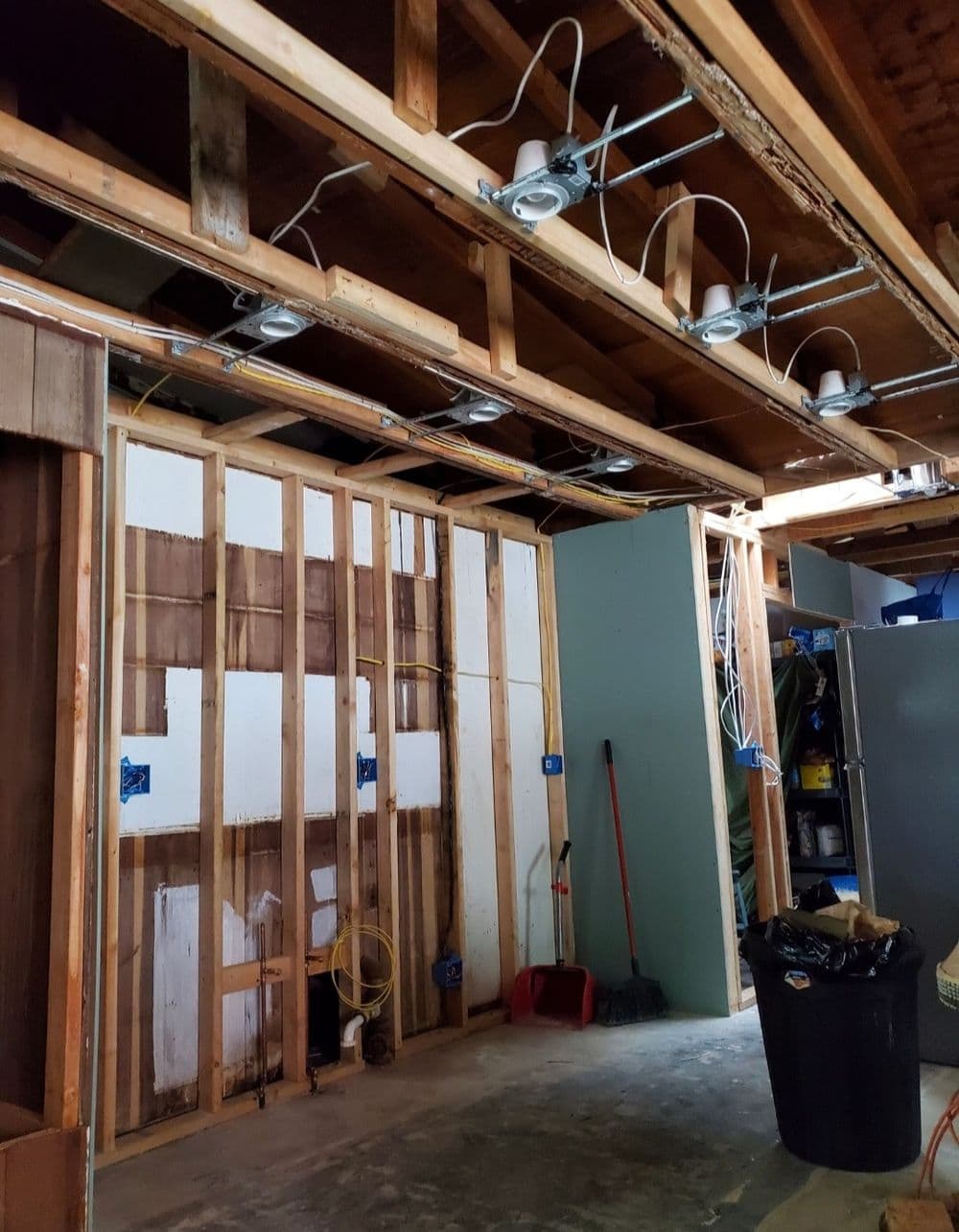 Interior renovation showing exposed wooden framing and electrical wiring in a partially finished space.