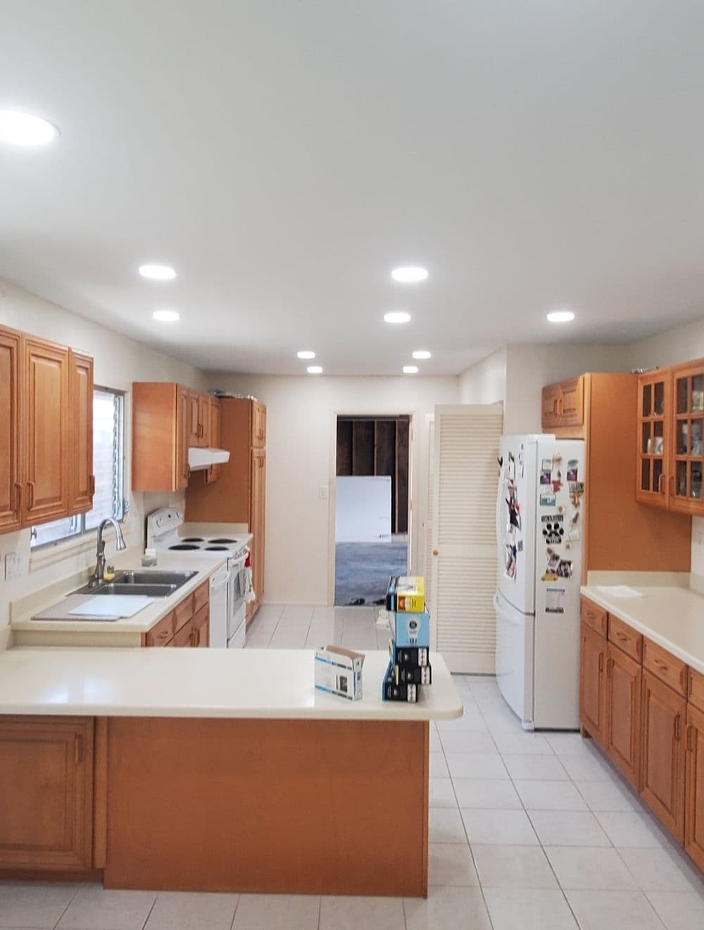 Bright kitchen with wooden cabinets, white appliances, and spacious layout for entertaining.