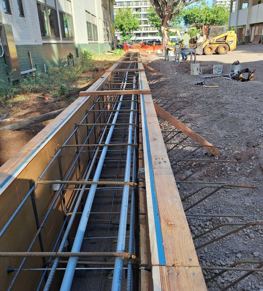 Construction site featuring a wooden framework and rebar for concrete pouring.