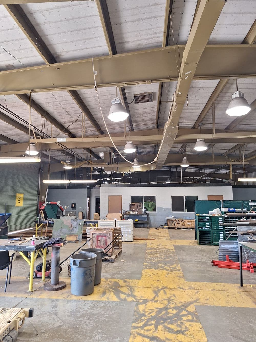 Interior of a workshop with tools, workstations, and overhead lighting.